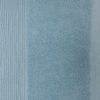 Close-up of a sky blue plush face cloth showing the soft looped cotton texture and ribbed border.