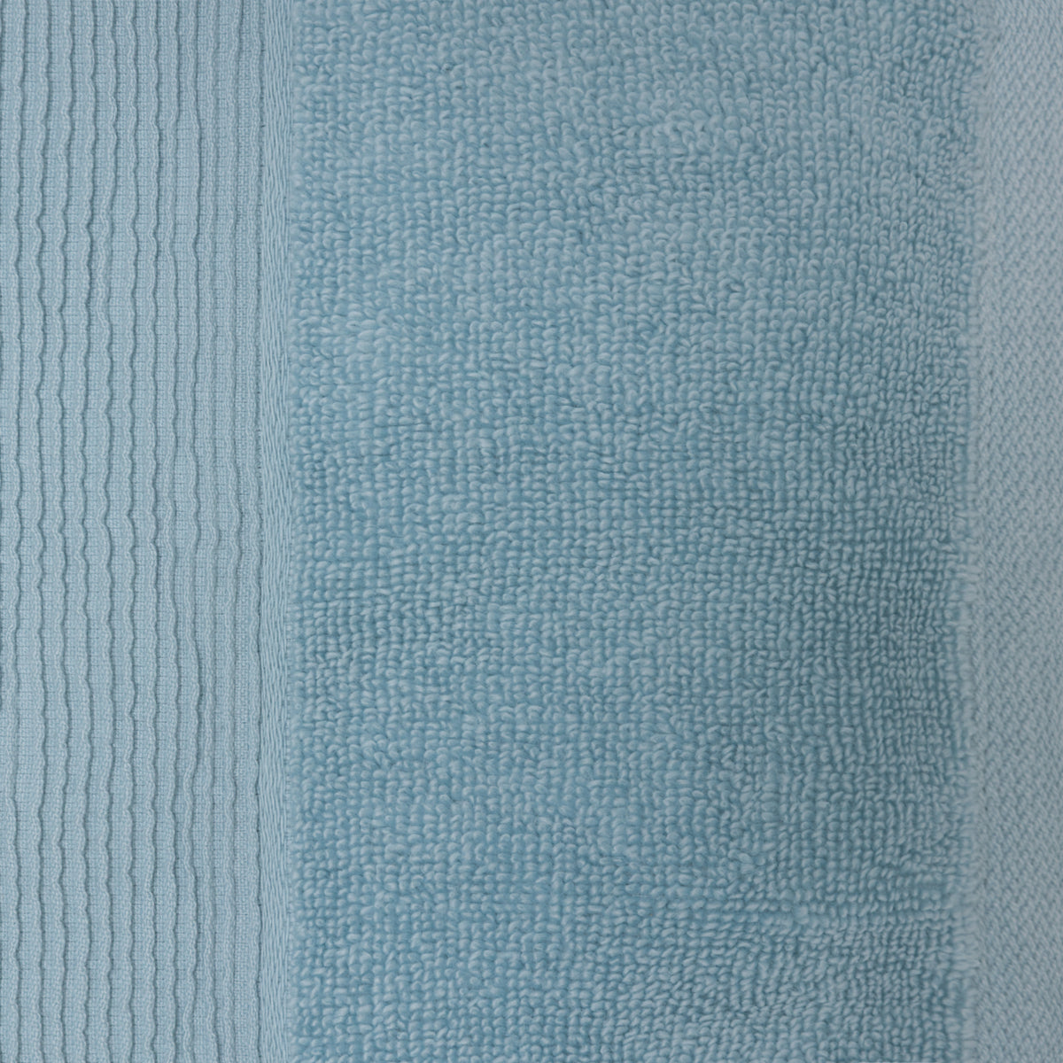 Close-up of a sky blue plush face cloth showing the soft looped cotton texture and ribbed border.