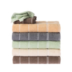 Home Co. Sara Stitch towel range displayed in a stacked arrangement of peach, charcoal, sage green, cream and mocha, with coordinating smaller towels placed on top.