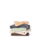 Home Co. Sara Stitch Hand Towels loosely stacked in peach, charcoal, sage green, cream and mocha, showing the plush textured finish and stitched stripe design.