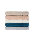 Neatly folded stack of Gracious Living Marilyn bath sheets in beige, peach, white, teal and silver, showing the subtle textured pattern and decorative border detailing.