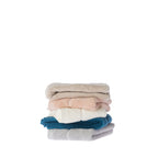 Stack of Gracious Living Marilyn hand towels in beige, peach, white, teal and silver, folded to show their plush texture and decorative detailing.