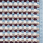 Close-up of the Berry Quinny Popcorn towel, showing the raised popcorn-style check texture in blue, berry, taupe and white with a blue woven border.