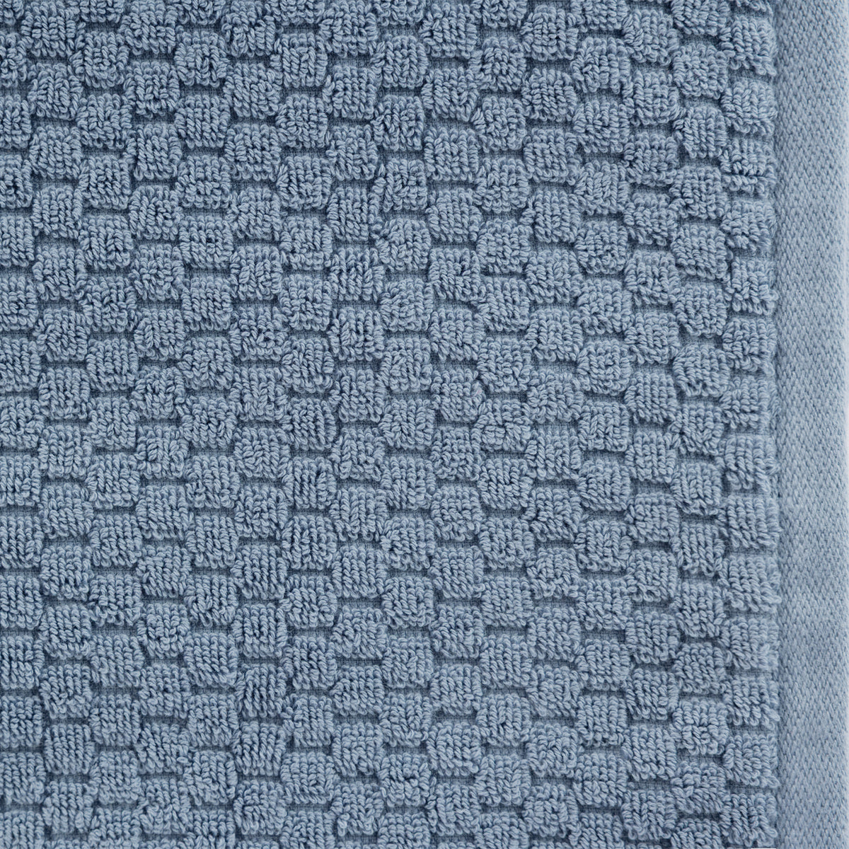 Close-up of the Design Republique Quinny Popcorn Bath Towel in Denim, featuring a soft blue raised loop texture with a matching border.