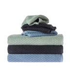 Assorted Design Republique Quinny Popcorn towels stacked in Sea Mist, Charcoal and Denim, showing the raised textured weave across multiple towel sizes.