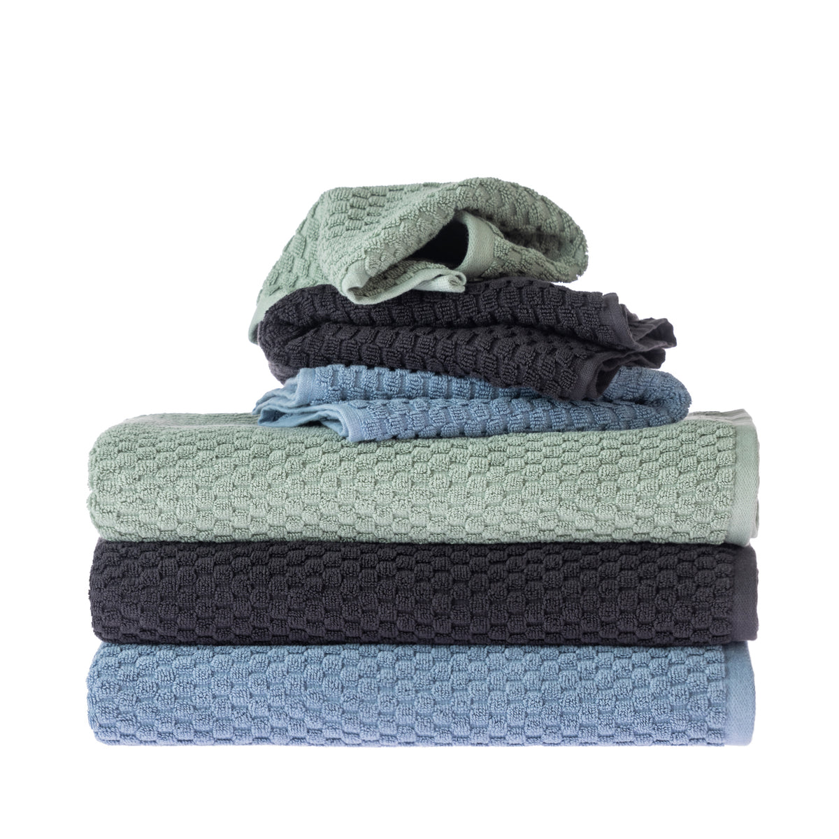 Assorted Design Republique Quinny Popcorn towels stacked in Sea Mist, Charcoal and Denim, showing the raised textured weave across multiple towel sizes.