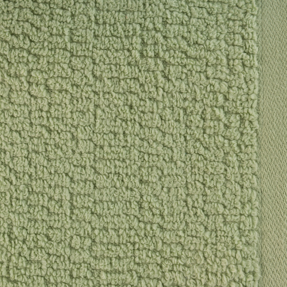 A close-up of the Home Co. Nevada Face Cloth 390gsm in Avocado, showcasing the soft sage green cotton fabric with a textured looped surface and neatly woven border.