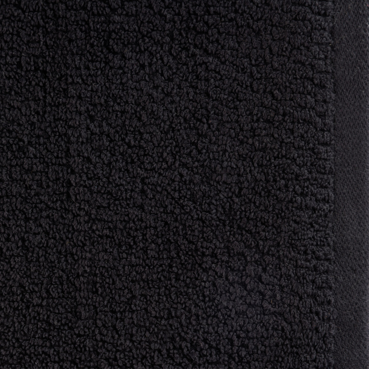 A close-up of the Home Co. Nevada Face Cloth 390gsm in Black, highlighting the textured cotton weave, soft looped fibres and smooth woven edging.