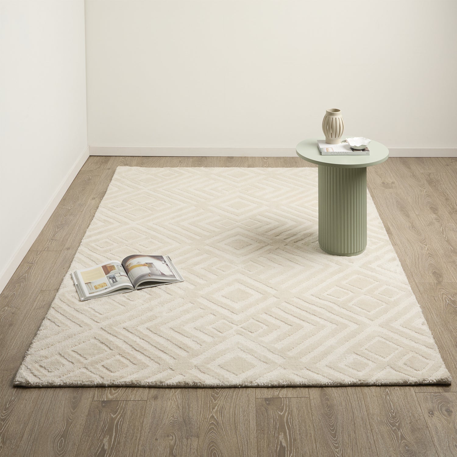 Brighton Rug 230 x 330cm in Natural, shown in a larger room setting with a cream textured surface and subtle geometric pattern.