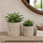Cove Sandy Arch Set of 2 Planters in stone, styled with green plants on a wooden console.