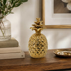 Design Republique Pippa Pineapple Décor Piece in gold, styled on a wooden surface with a glossy pineapple design.