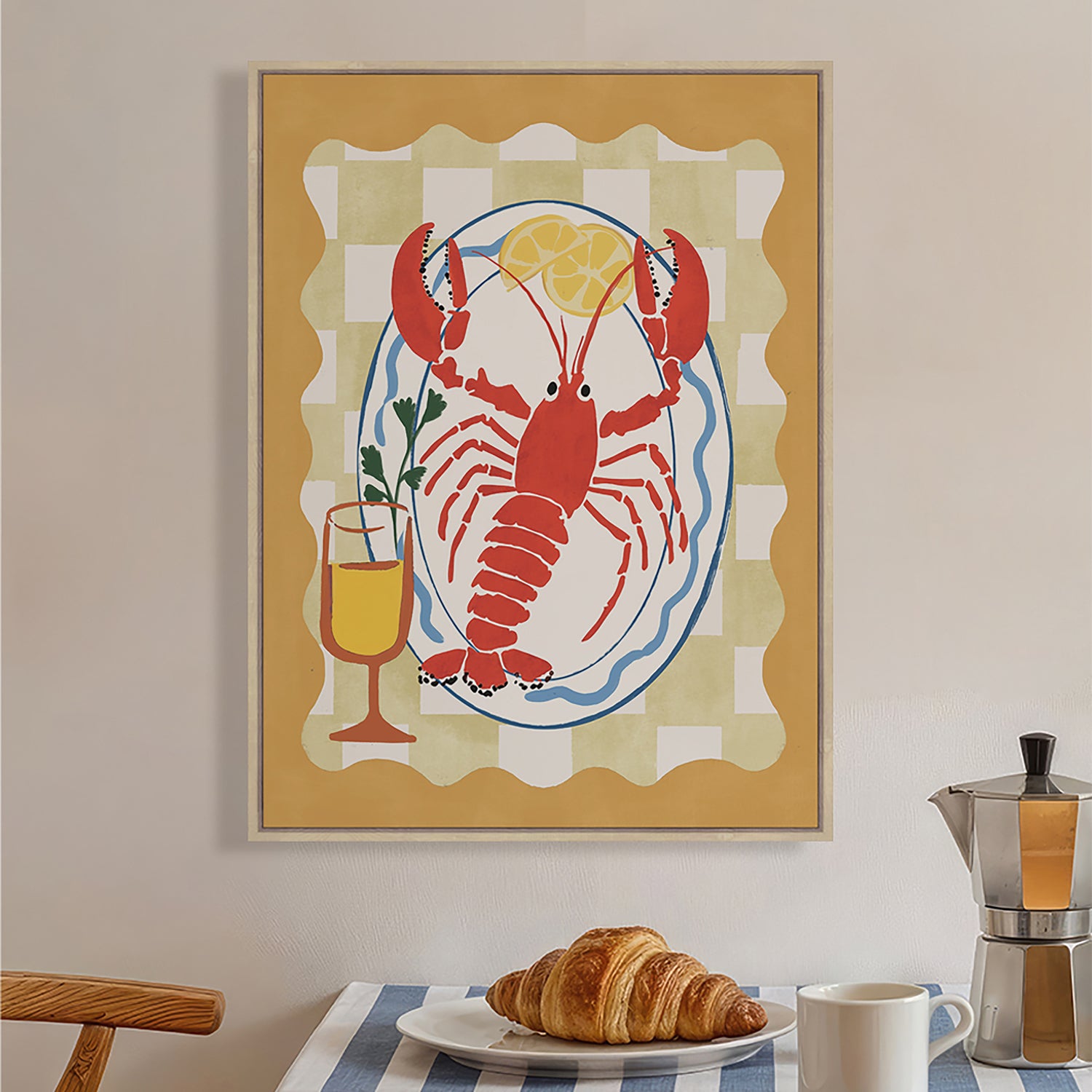 Design Republique Lobster Dish Framed Canvas styled on a kitchen wall above a breakfast setting, featuring a bright lobster, lemon and drink illustration.