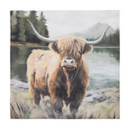 A charming Highland cow stands beside a tranquil mountain lake, with misty forest and alpine scenery creating a warm, rustic countryside scene.