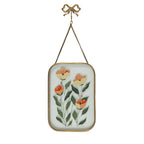 Gold framed glass wall art with orange floral artwork and bow hanging hook on a white background.