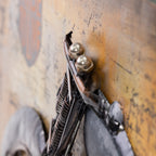 Close-up of the motorcycle metal wall art showing the raised handlebars, headlights, springs and layered metal detailing.