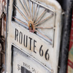Close-up of a distressed decorative wall art featuring a vintage design and the text 'ROUTE 66' in black on an off-white painted panel.