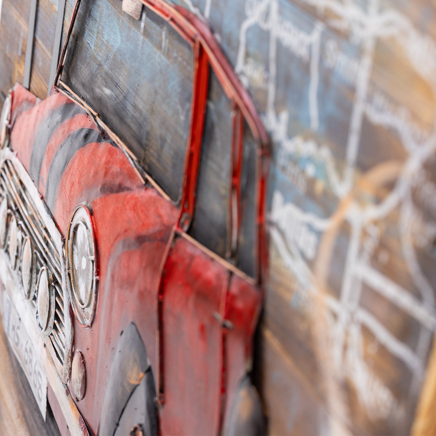 A close-up of a red vintage-style car 3D wall art piece set against a blurred toned background.