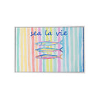 A framed art print featuring the phrase 'sea la vie' in blue script above 3 colourful striped fish, set against a background of pastel vertical stripes in pink, yellow, green, blue, and orange.