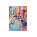 A colorful painting of a Venice canal scene with bright buildings in pink, orange, yellow, and purple, boats moored along the water, and reflections in the canal, shown centered on a white background.