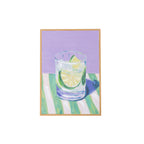 A framed painting of a glass of a gin & tonic with a lemon slice, set against a lavender background and green-and-white striped table, shown on a plain white background.