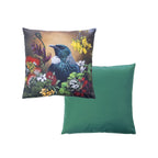An outdoor cushion front and reverse features a detailed print of a Tui bird among colorful flowers on a warm background, while the reverse pillow shows a solid green fabric surface.