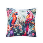 A outdoor cushion featuring a vibrant tropical print with two colorful macaws perched among lush green leaves and pink flowers, shown against a plain white background.