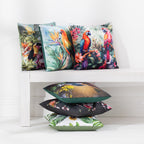 A collection of outdoor cushions with various colorful tropical and nature prints, arranged on and beside a white wooden bench against a white wall.