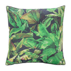 An outdoor euro cushion featuring a vibrant green tropical banana leaf pattern on a dark charcoal background, shown against a plain white studio backdrop.