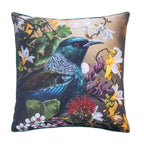 An outdoor euro cushion featuring a detailed illustration of a Tui bird surrounded by colorful native flowers on a warm background, with a dark green fabric border.