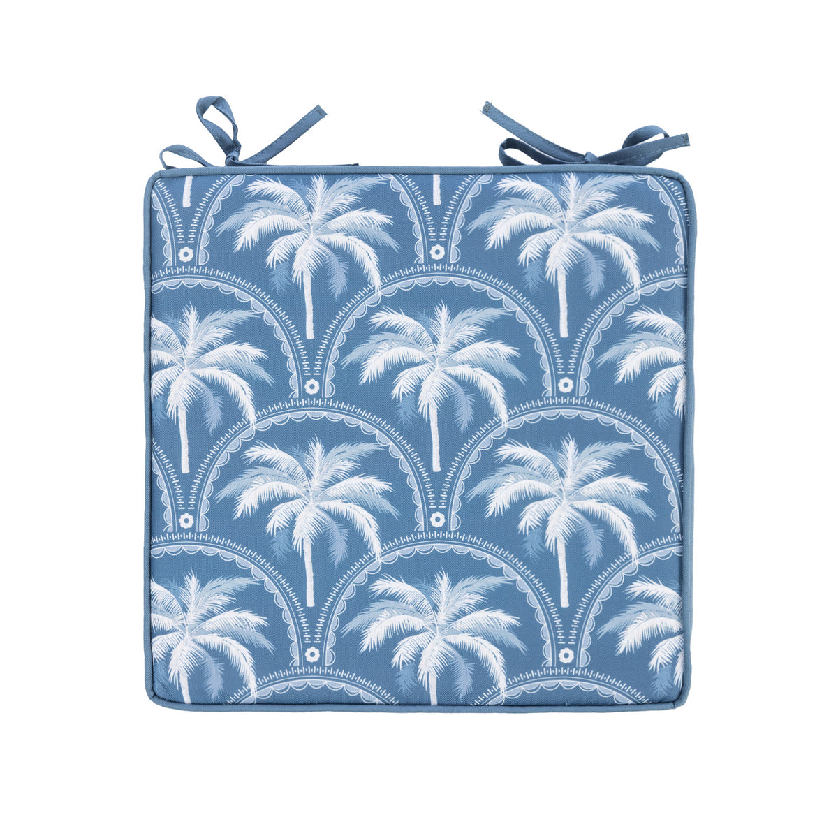A outdoor chair pad with a white palm tree and scalloped arch pattern, finished with two matching blue tie straps at the top corners, shown on a plain white background.