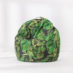 A bean bag chair featuring a vibrant green tropical leaf pattern on a black background, set against a clean white studio backdrop.