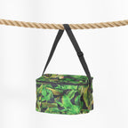 A green tropical leaf print cooler bag with black straps, hanging from a thick natural rope against a clean white background.