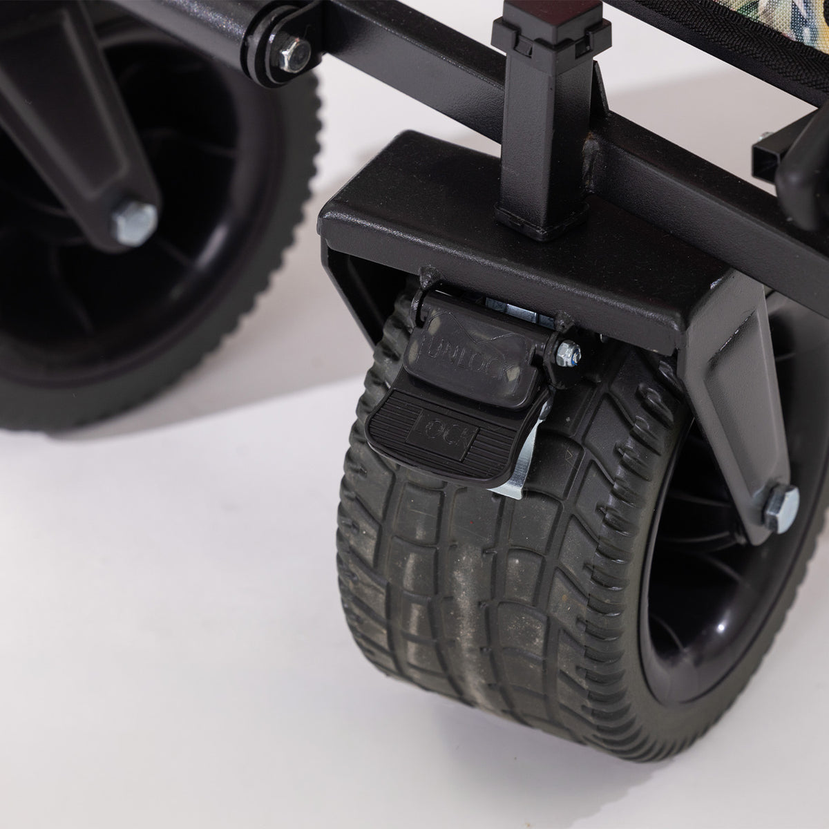 Close-up of the beach trolley’s wide black wheel with locking brake.
