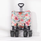 Folded hibiscus-print beach trolley shown upright with four wide wheels and an extended pull handle.