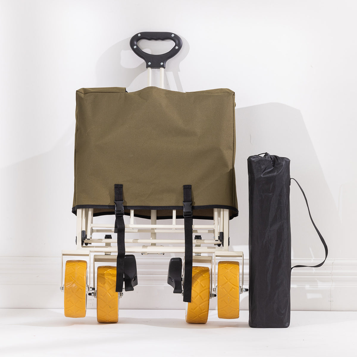Folded green trolley shown with its pull handle extended, yellow wheels visible and black carry bag beside it.