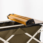 Folded slatted tabletop shown resting on top of the green trolley.