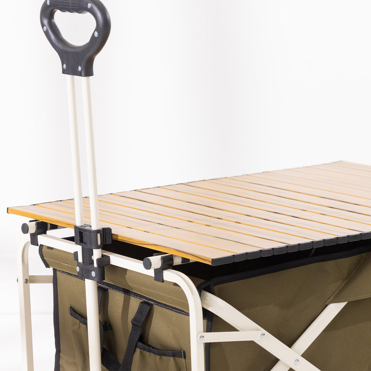 Close-up of the trolley’s pull handle and removable slatted tabletop fitted over the green fabric body.