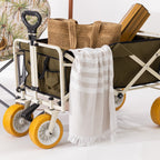 Green folding trolley loaded with outdoor essentials, featuring yellow all-terrain wheels, an extended pull handle and side storage pockets.