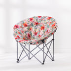 A round fabric moon lounge chair with a vibrant red, orange, and green tropical floral print, supported by a silver metal folding frame, set against a clean white studio background.
