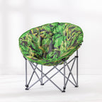 A round fabric moon lounge chair with a vibrant green tropical leaf print, supported by a silver metal folding frame, set against a clean white studio background.