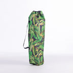 A drawstring moon chair bag with a green tropical banana leaf pattern, standing upright on a white studio background.