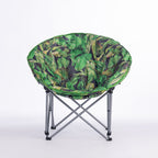 A round folding moon chair with a green tropical leaf print fabric cushion on a silver metal frame, photographed against a seamless white studio background.