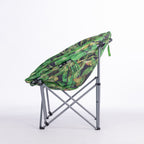 A round folding moon chair with a green tropical leaf print fabric cushion on a silver metal frame, photographed against a seamless white studio background.