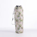 A drawstring moon chair bag featuring a green palm tree pattern on a ivory background, with a black drawstring closure and a black carrying strap, shown on a white studio background.