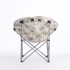 A folding moon chair with a ivory-colored fabric seat cushion featuring a green palm tree pattern, supported by a silver metal frame, shown against a plain white background.