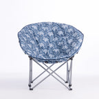 A folding moon chair with a blue and white palm tree patterned fabric seat cushion and a silver metal frame, shown on a plain white background.