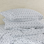 Floral patterned bedding flat sheet on a beige bed frame