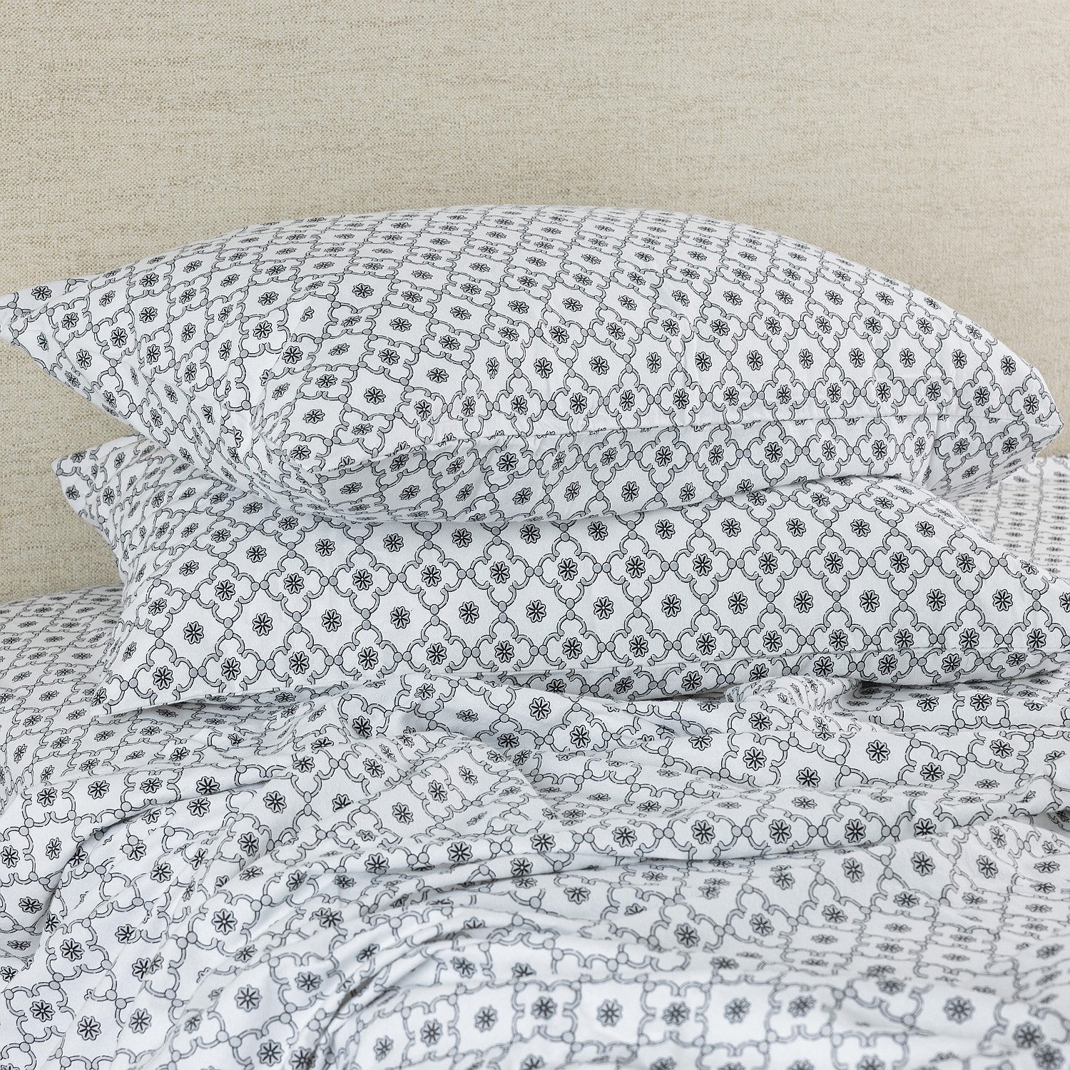 Floral patterned bedding flat sheet on a beige bed frame