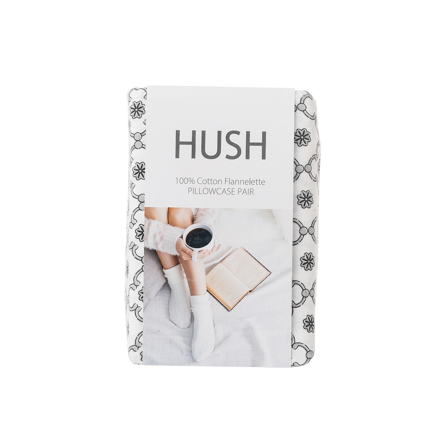Packaged Hush pillowcases with a person holding a cup and book on a white background