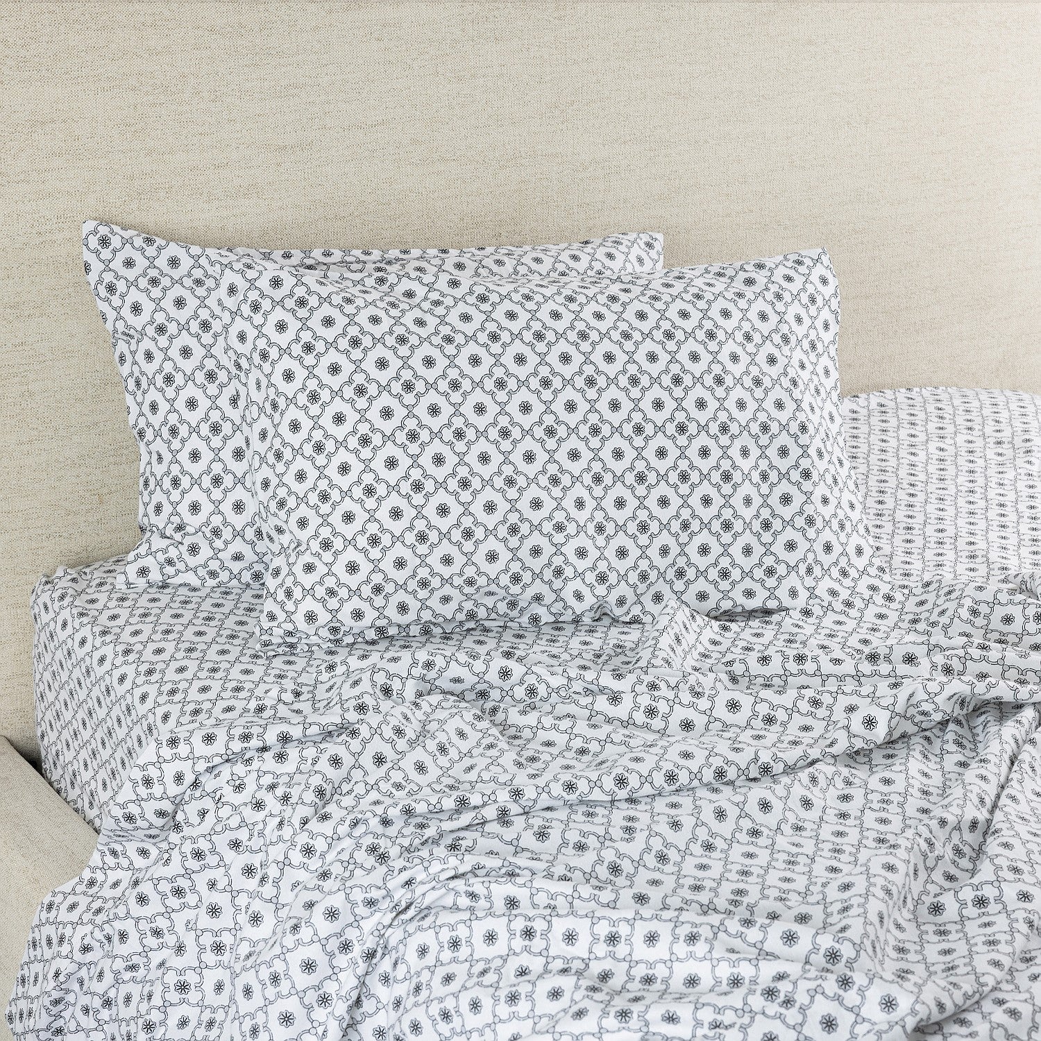 Gray patterned bedding set on a beige bed